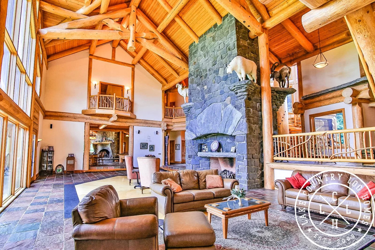 The Great Room's monumental stone fireplace beneath the exposed Douglas Fir roof structure