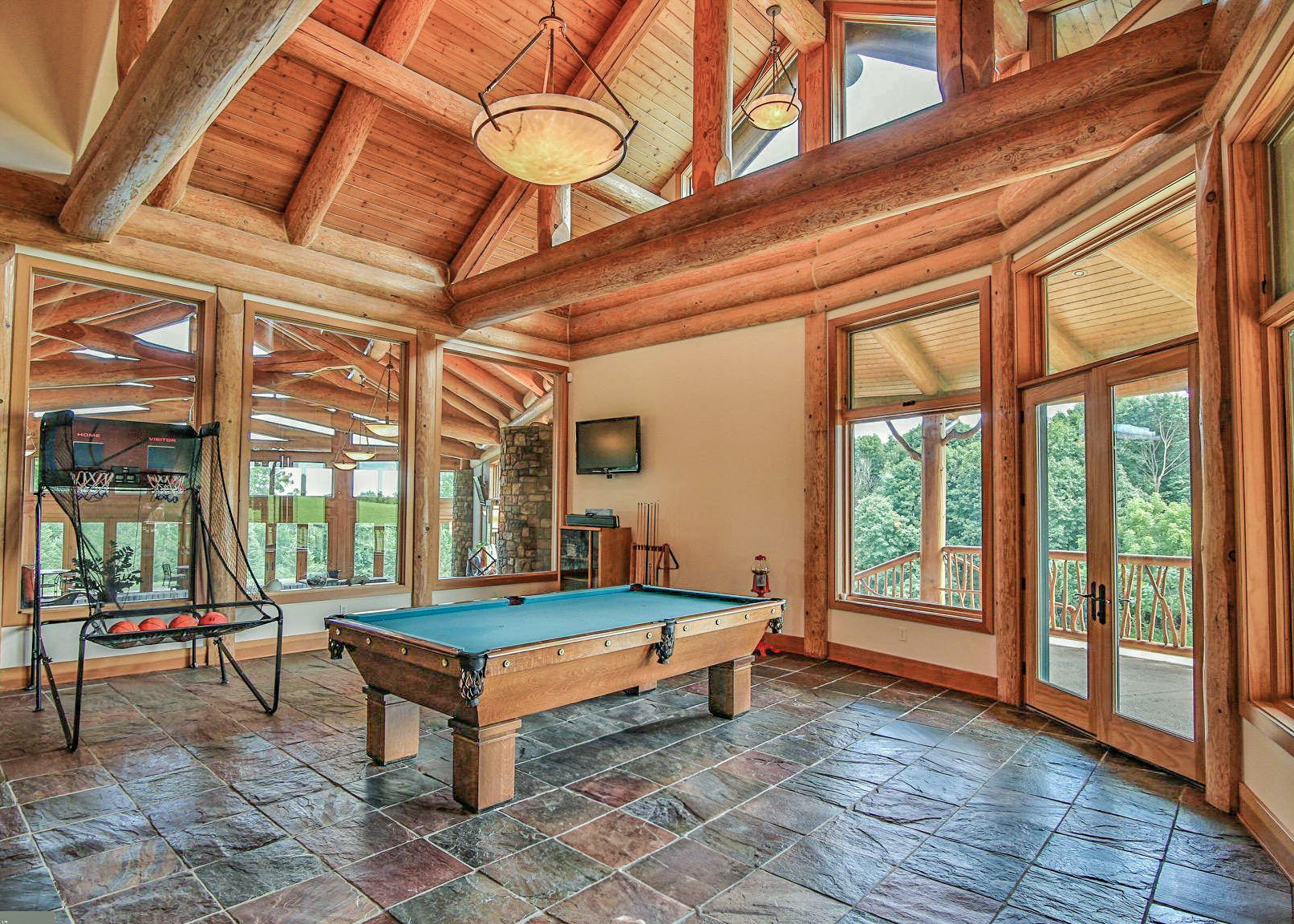 A bright game room framed by exposed Douglas Fir logs and large windows